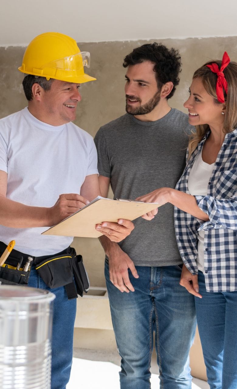 Contractor talking to a couple while remodeling their house